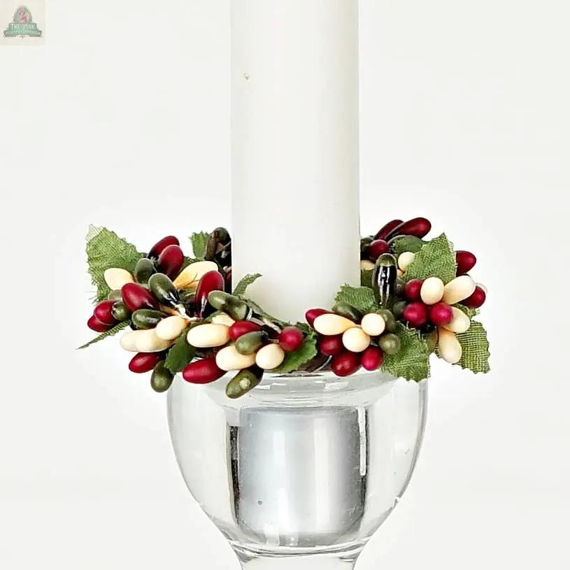 The ISB13700FH 1.5in Pip Berry Taper Ring features artificial red, white, and green berries with fabric leaves, making it a perfect farmhouse accent for candles or use as a decorative napkin ring.