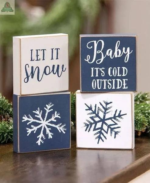 The Let It Snow/Snowflake Square Block set includes four assorted wooden blocks—two with snowflake designs and two with winter phrases—perfect for farmhouse winter decor.