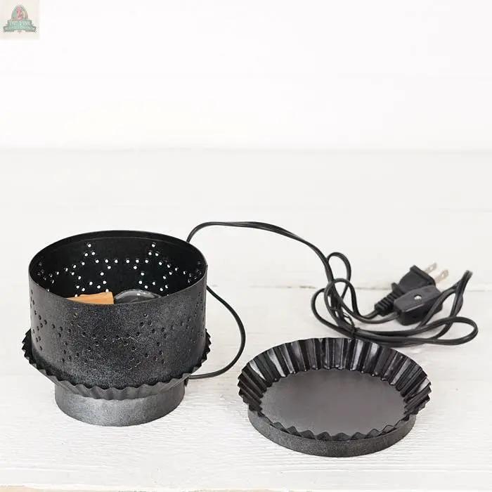 The Electric Tart Warmer-Pewter-, featuring a black perforated cylindrical body, pewter finish, power cord, and flat round removable tray, is shown on a white surface.