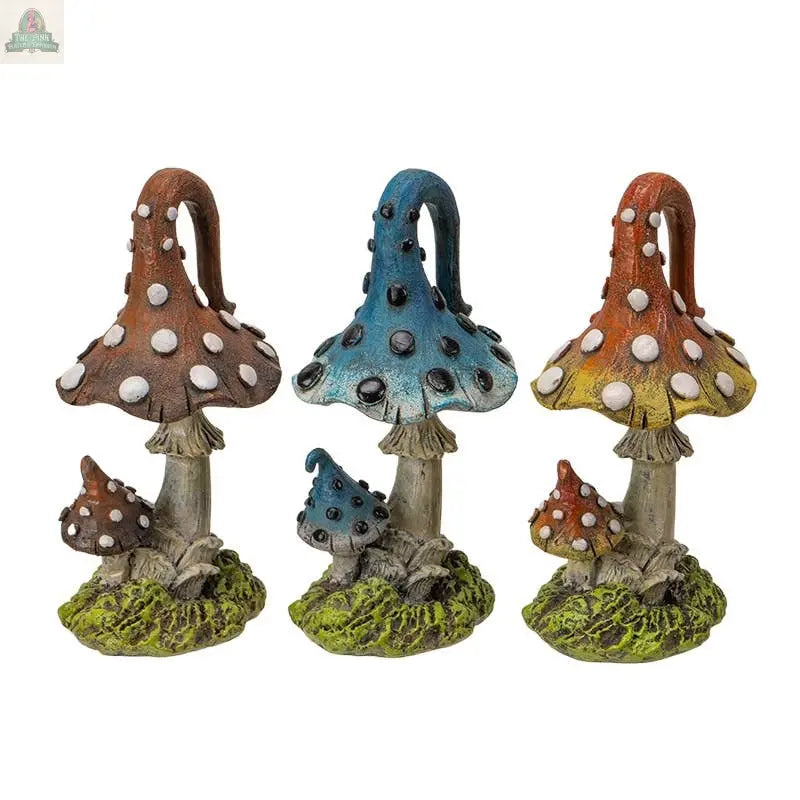 The Magic Mushroom Toadstools Home and Garden Decor Set of 3 includes brown, blue, and yellow mushroom statues with white spots, green bases, and textured details—ideal as whimsical garden decor or playful toadstool accents for your space.
