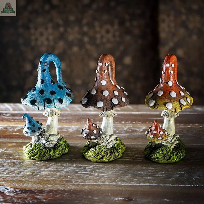 The Magic Mushroom Toadstools Home and Garden Decor Set of 3 features blue, brown, and orange mushroom statues with white spots, each with a matching snail at the base—perfect for adding charm to your garden or home.