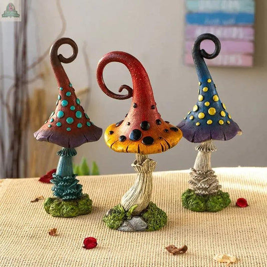 Three whimsical Magic Toadstool Mushrooms Home and Garden Decor statues with curly tops and polka dots sit on a burlap surface, surrounded by moss and dried petals—adding a charming, cottagecore touch. A blurred sign appears in the background.