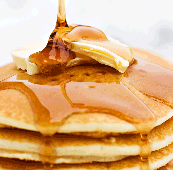 A close-up of pancakes with melting butter and maple syrup dripping down, capturing the cozy aroma of Maple Butter Atomizer Oils filling the air with sweet, warm notes.