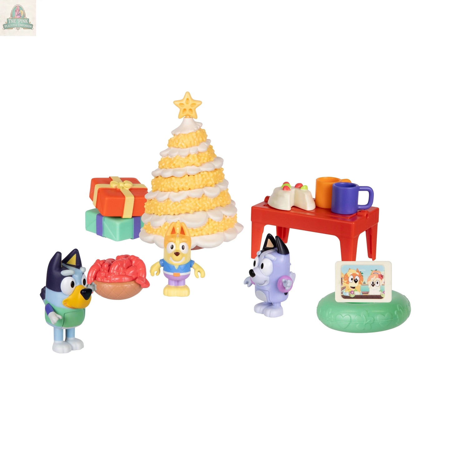 The Bluey Advent Calendar includes toy figurines with Christmas presents, a festive tree cake, a red treat table, a green stand with a screen showing two characters, all on a white background.