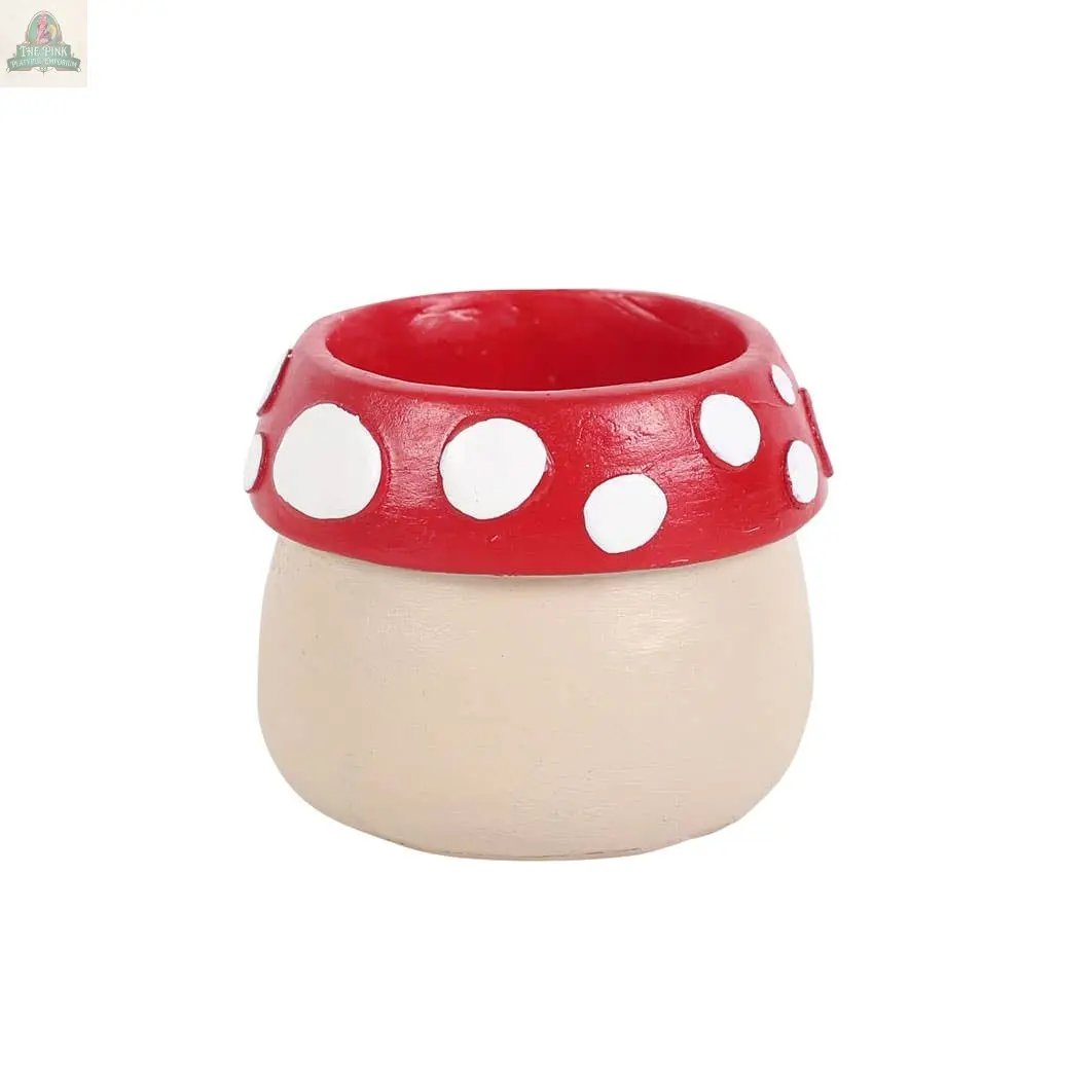 The Mushroom House Resin Tealight Holder features a charming mushroom design with a beige base and red cap with white spots, perfect for adding whimsical winter forest decor to your home.