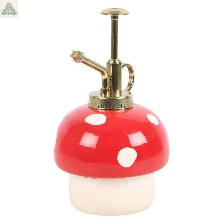 The Mushroom Shaped Plant Mister features a red and white toadstool design with a shiny brass spray nozzle—perfect for bringing cottagecore charm or enchanted forest vibes to your indoor garden.