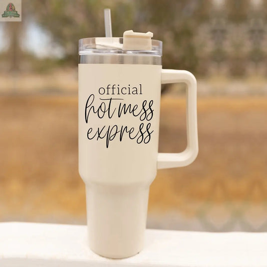 The Official Hot Mess 40oz is a large, cream-colored insulated tumbler with a handle, clear lid, and straw. The cup features “Official Hot Mess Express” in black script and regular fonts on its surface.