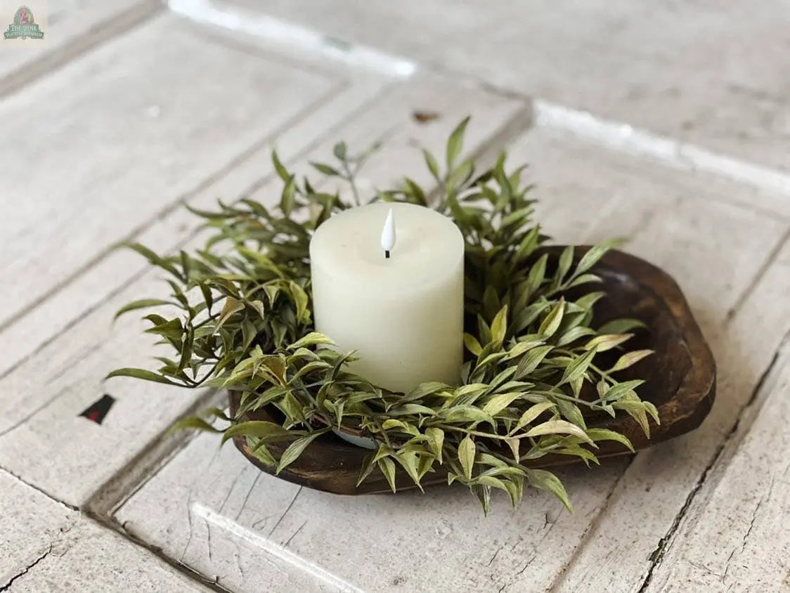 The Petite Wood Bowl, Candle Ready, Handmade, #A - 7.1 holds a white pillar candle surrounded by green foliage on a rustic white wooden surface.