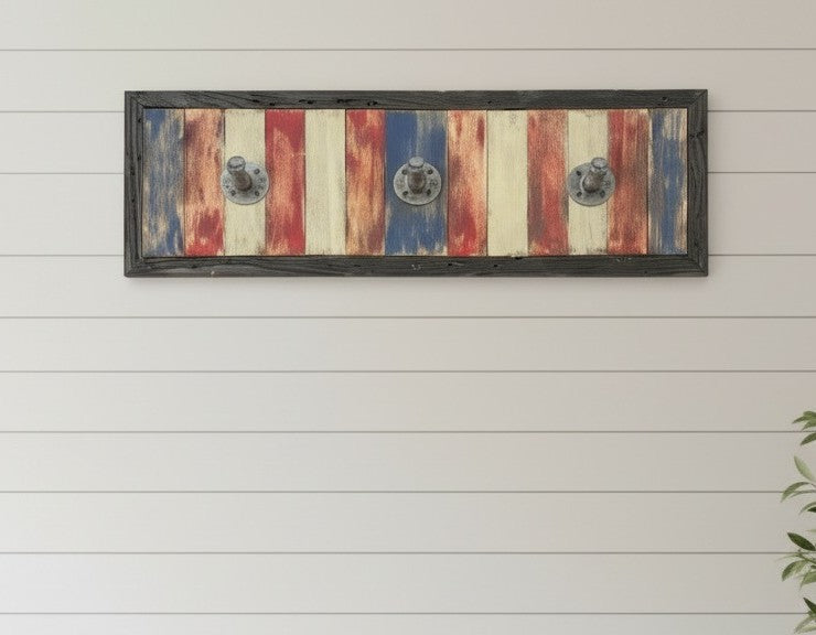 Decorative wall art with a wooden frame featuring red, white, and blue stripes on a white wooden panel background.