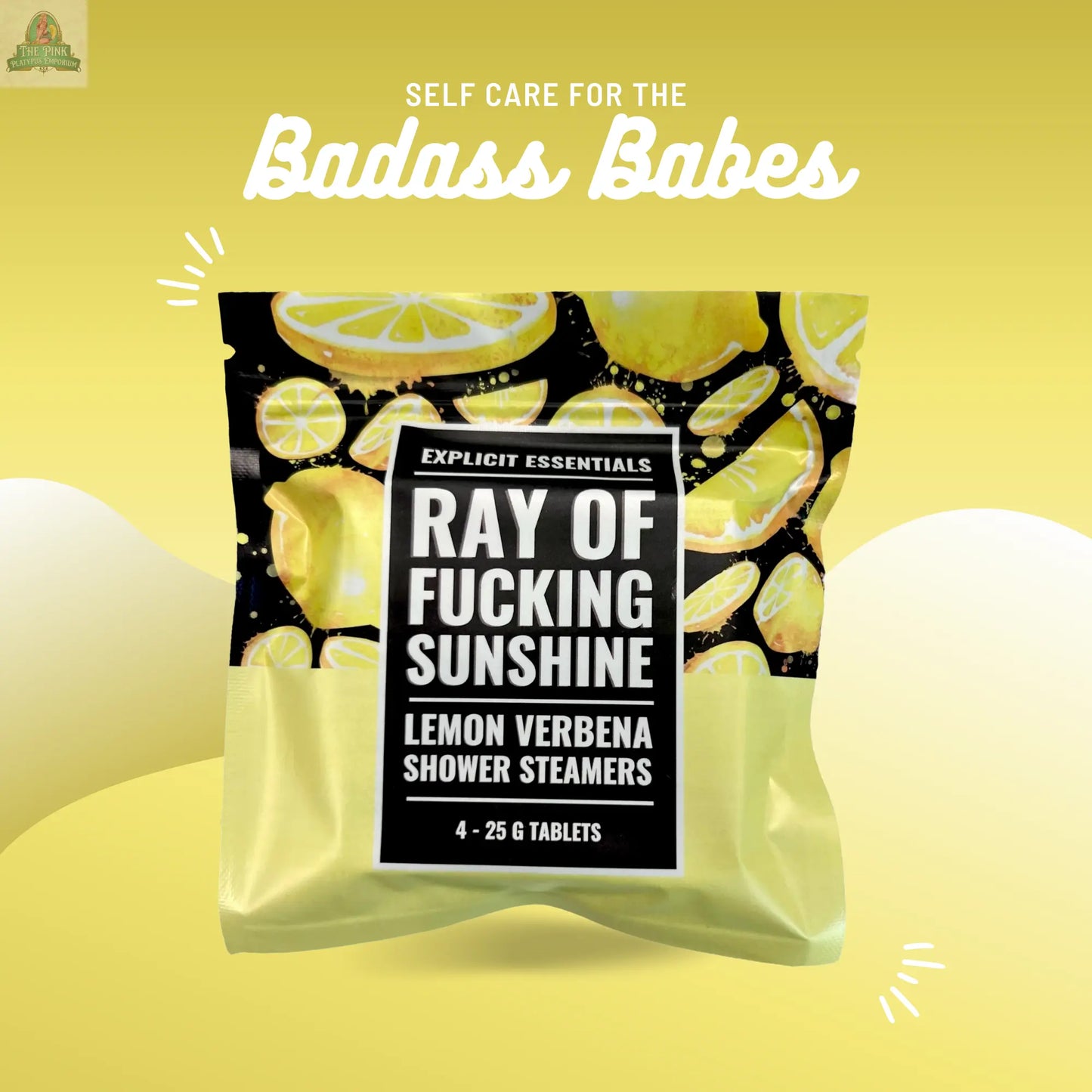 A package of Ray of F&cking Sunshine Shower Steamers by Explicit Essentials sits on a yellow background with lemon slices, under the text "Self care for the badass babes—infused with mood-boosting essential oils.