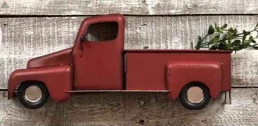 The Red Half Farm Truck is a vintage-inspired wall decor piece, featuring a red pickup with green foliage in the bed—perfect for adding rustic charm to any farmhouse-style space.