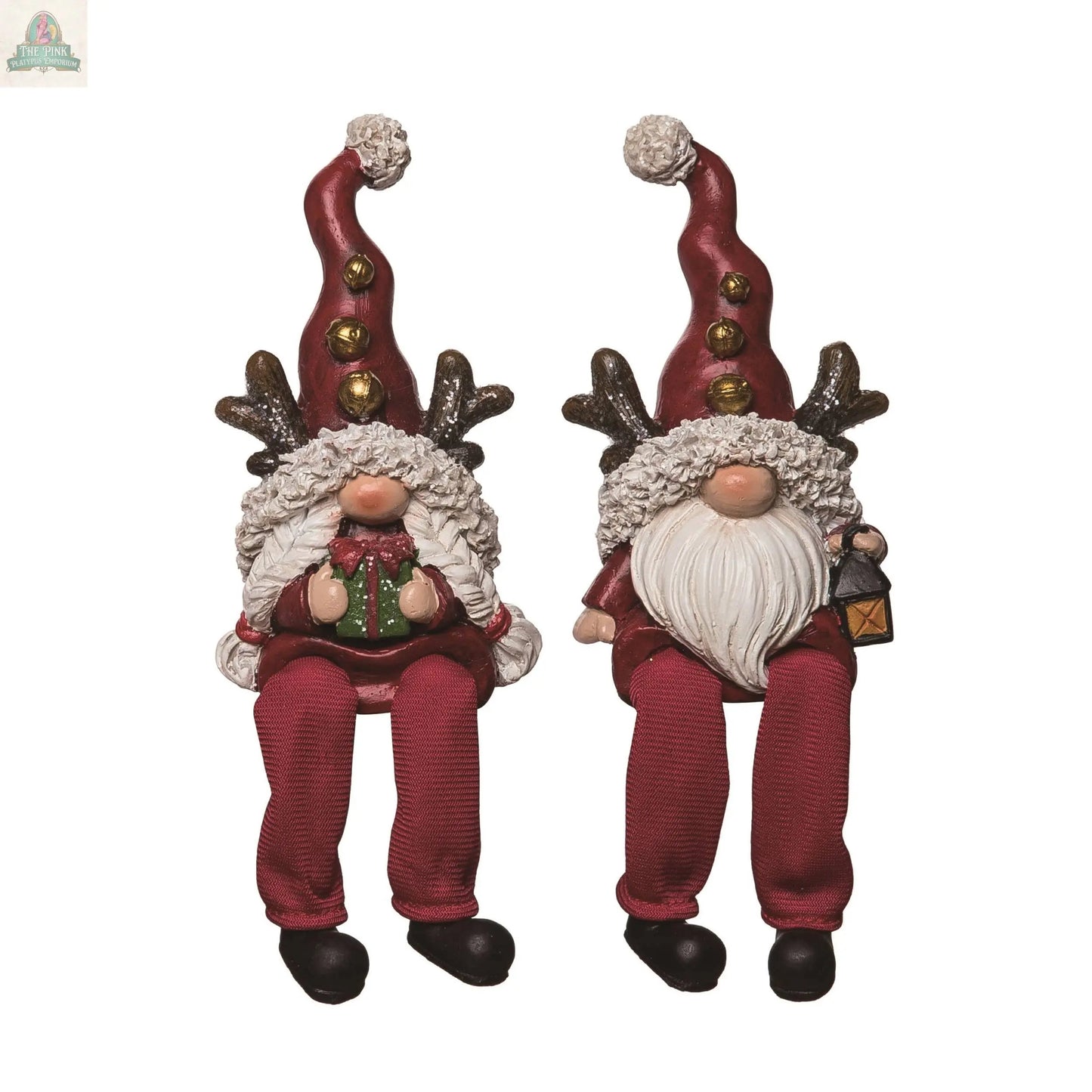 Resin Christmas Gnome Shelf Sitters with long red hats, reindeer antlers, festive outfits, dangling legs, and white pom-poms—one holds a present, the other a lantern. Charming holiday décor for shelves or mantels.