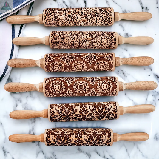 Six Rolling Pins - Box Style with engraved floral and geometric patterns are arranged on a white marble surface—ideal baking gifts for anyone who loves unique, detailed designs.