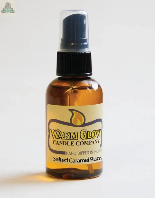A small amber spray bottle labeled Salted Caramel Rum Atomizer Oil, with a black cap and cream label featuring a flame graphic—ideal for refreshing potpourri or adding rich fragrance to any space.