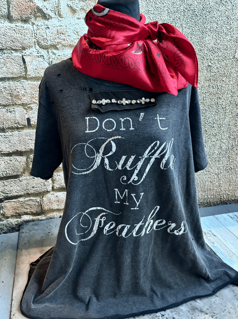 Gray shirt with 'Don't Ruffle My Feathers' text and red bandana on a textured wall background