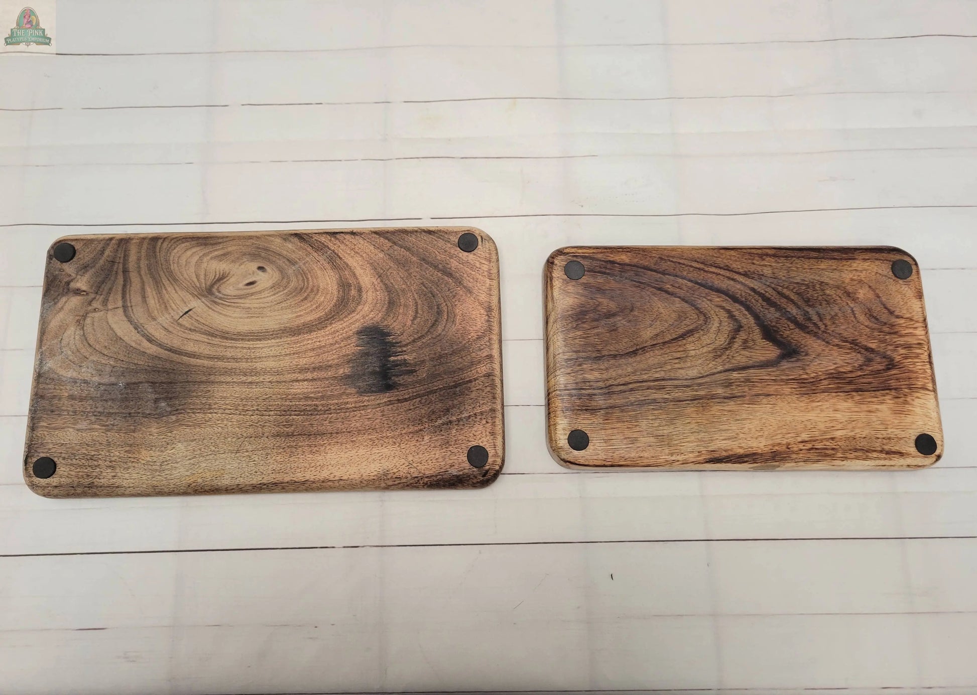 Two rectangular Wood Trays with visible grain and matte black corner pads are placed side by side on a light-colored tiled surface.
