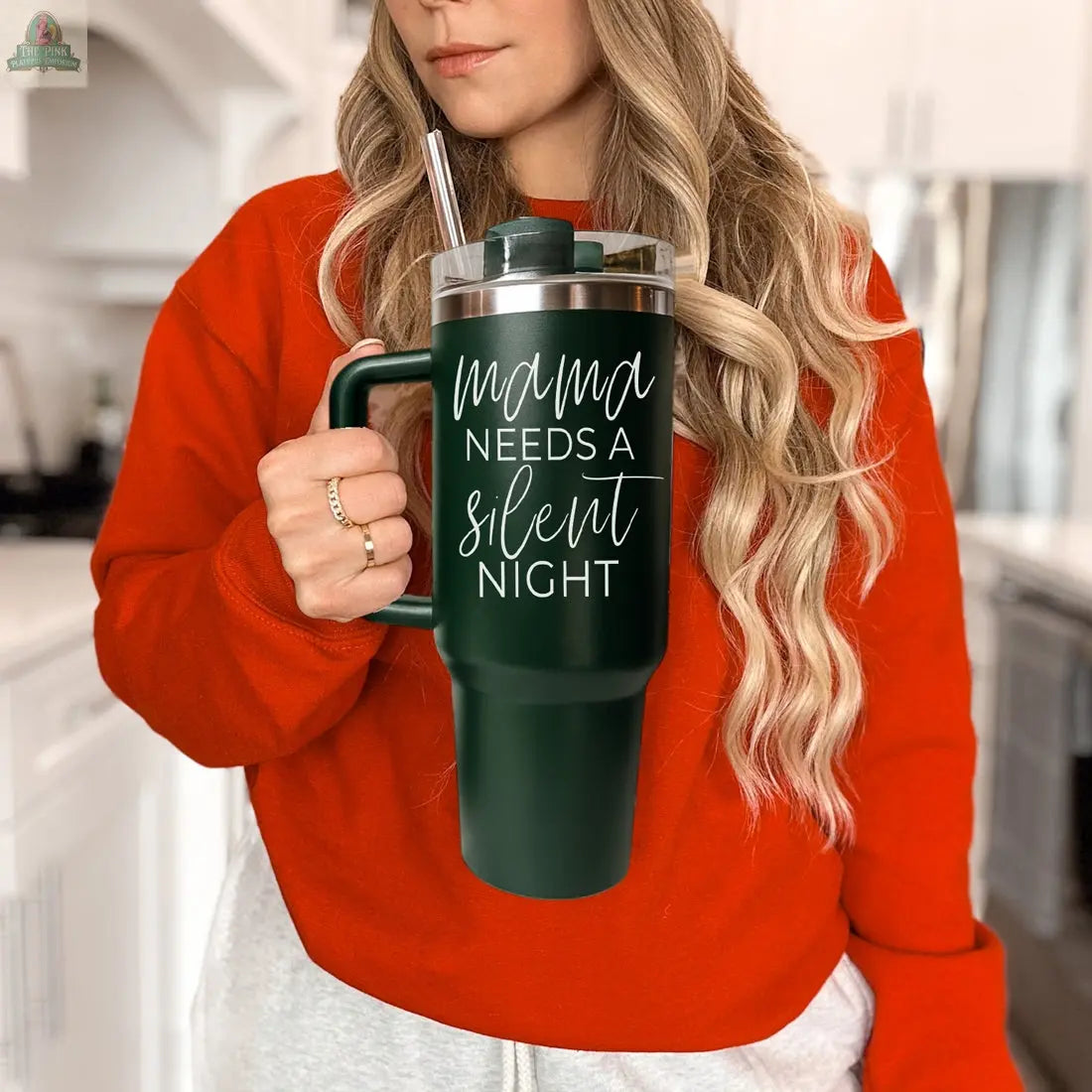 A woman in a red sweater holds the Silent Night 40oz tumbler with a straw, displaying "Mama needs a silent night" in white script. She stands in a bright kitchen, highlighting this perfect Christmas gift for moms.