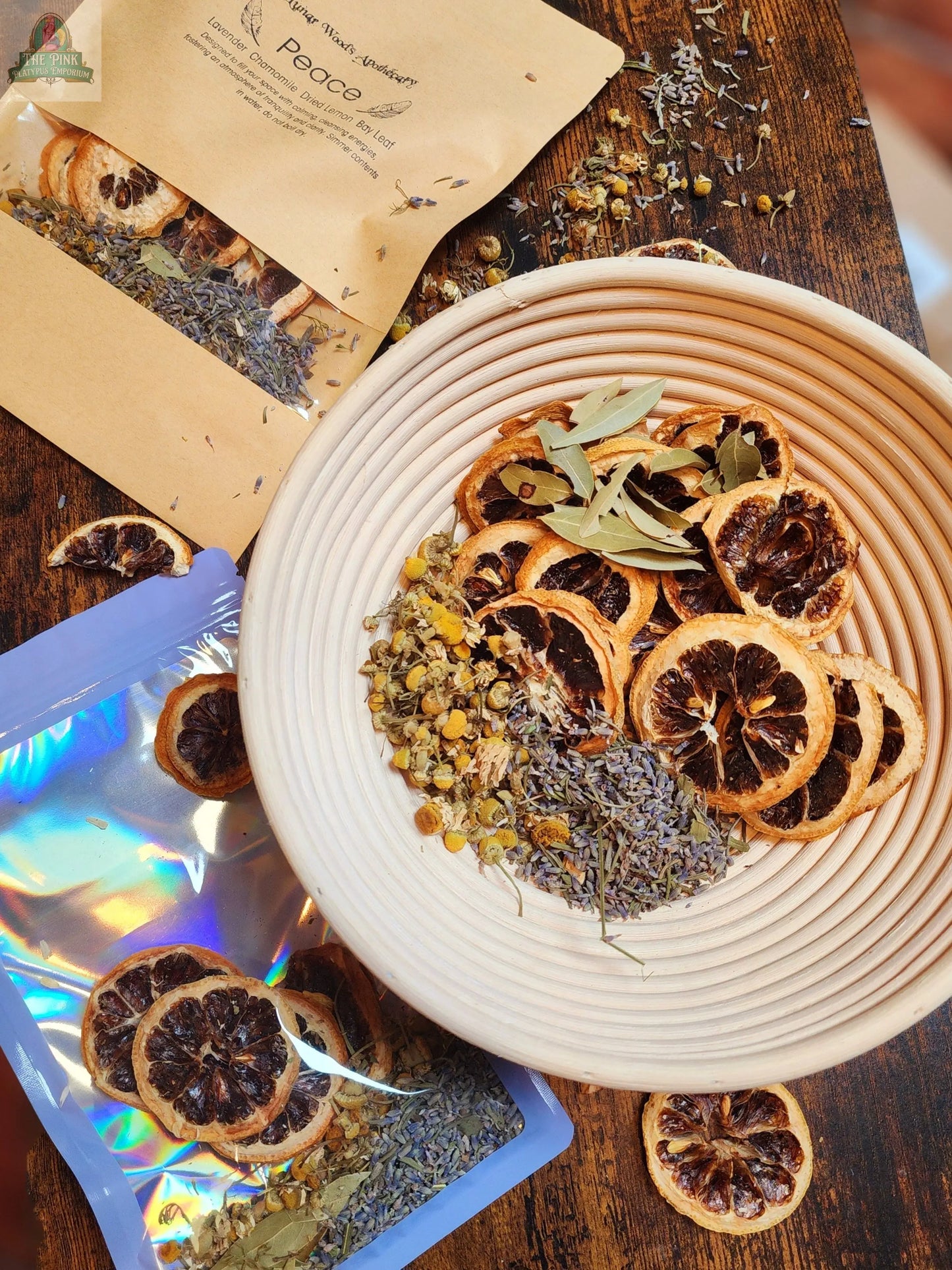The Simmer Pot Kit- Peace features a ceramic bowl filled with dried orange slices, lavender, chamomile, and bay leaves. Nearby, open bags display extra botanicals—ideal for creating a calming environment at home.