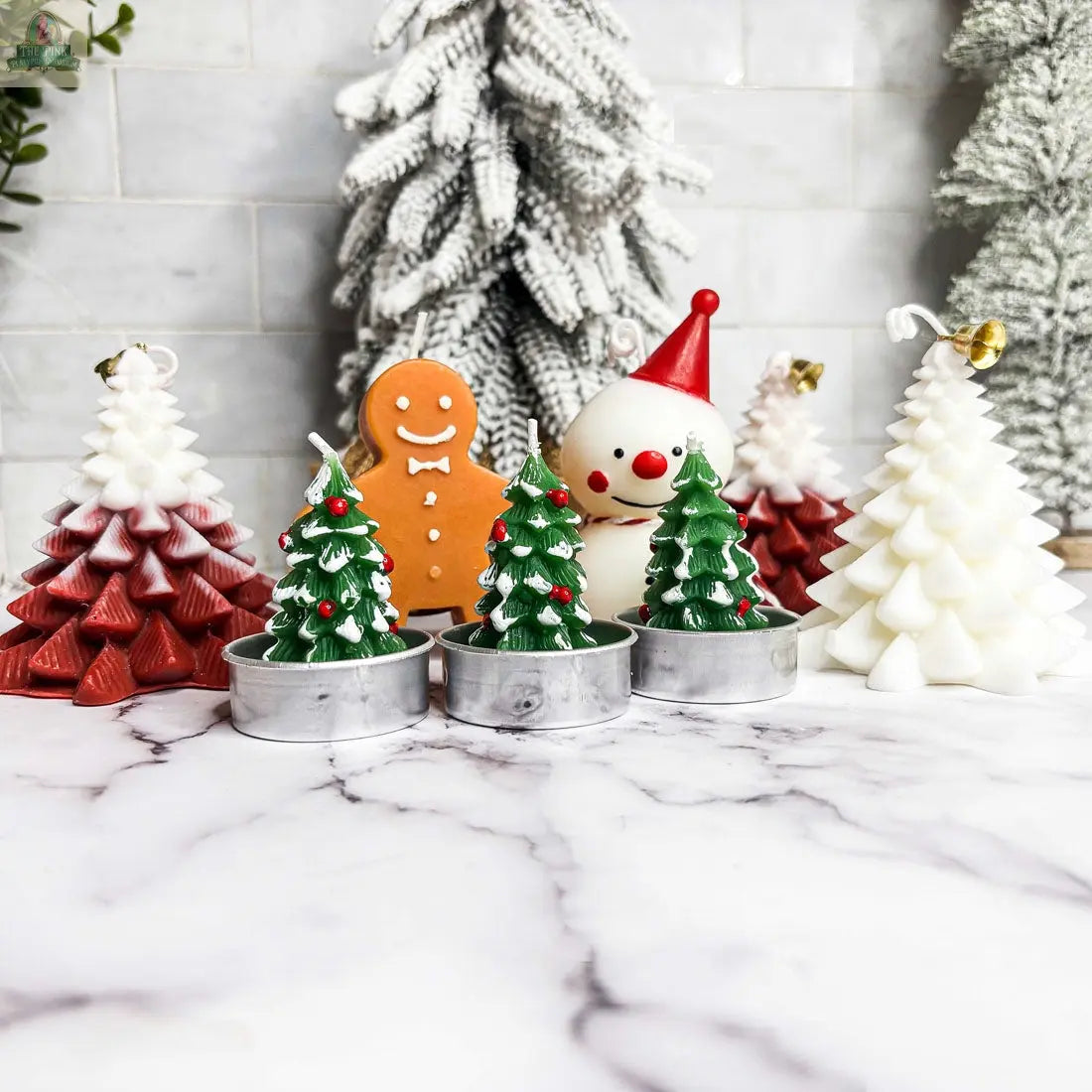 The Snowman Candle, shaped like a festive snowman in white, is a perfect winter home decor piece for the holidays—displayed on a marble surface with snowy trees in the background, it adds cheerful charm to any space.