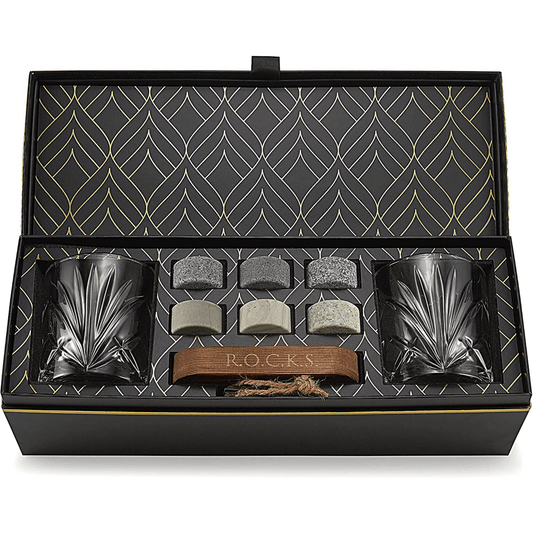 The Connoisseur's Set - Palm Whiskey Glass Edition includes two crystal whiskey glasses, six whiskey stones, metal tongs, and a burlap bag, all beautifully presented in a sleek black and gold-patterned box.
