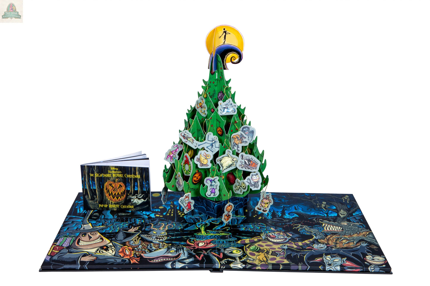 The Nightmare Before Christmas: Advent Calendar & Pop-Up Book features a 3D green pop-up tree, character tokens, a small illustrated book, and a colorful game board with spooky artwork inspired by Tim Burton’s film.