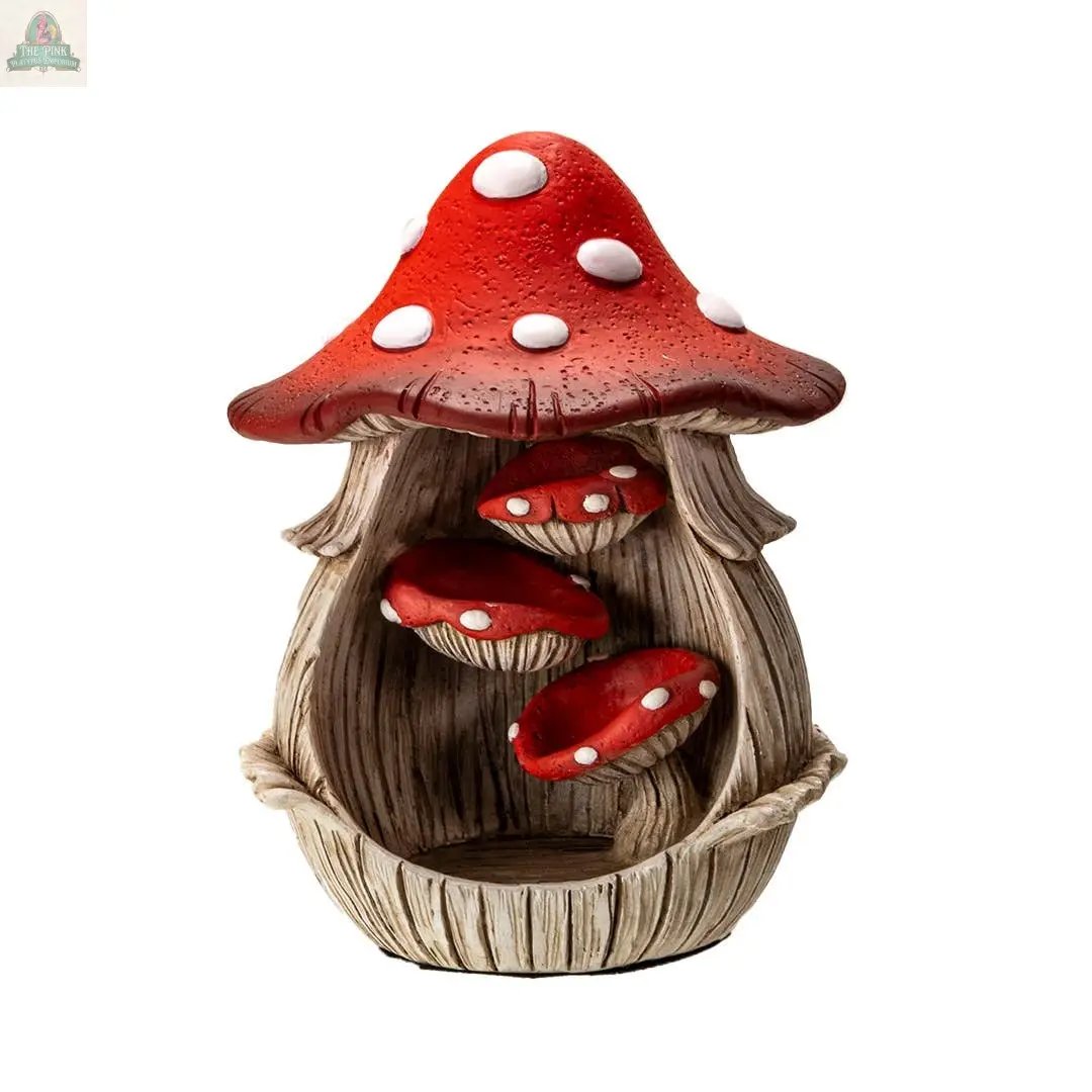The Toadstool Mushroom Backflow Waterfall Incense Burner features a whimsical red-capped mushroom house with white spots and smaller mushrooms inside a wood-like base—perfect for adding a magical touch to your space.