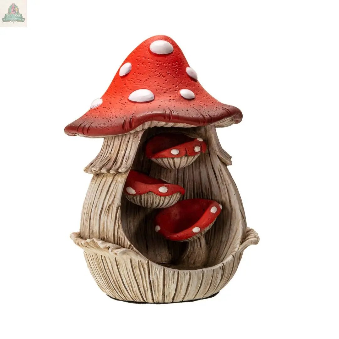 The Toadstool Mushroom Backflow Waterfall Incense Burner features a red and white spotted mushroom house with a large cap, three smaller mushrooms inside, and wood-like stems—adding whimsical charm to your décor.