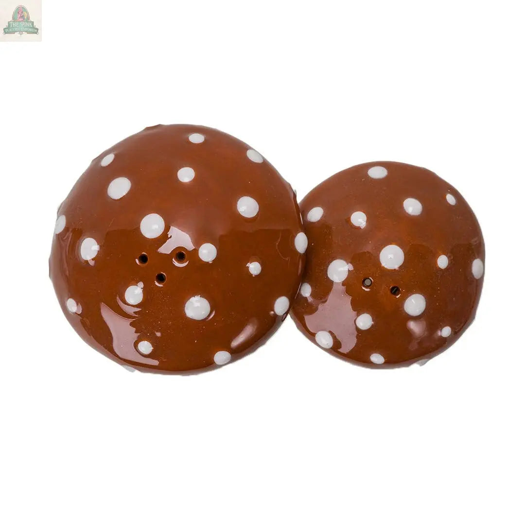 The Toadstool Mushrooms Salt and Pepper Shaker Set features two brown ceramic shakers with white polka dots, shown from above on a white background—a charming addition to your kitchen décor.