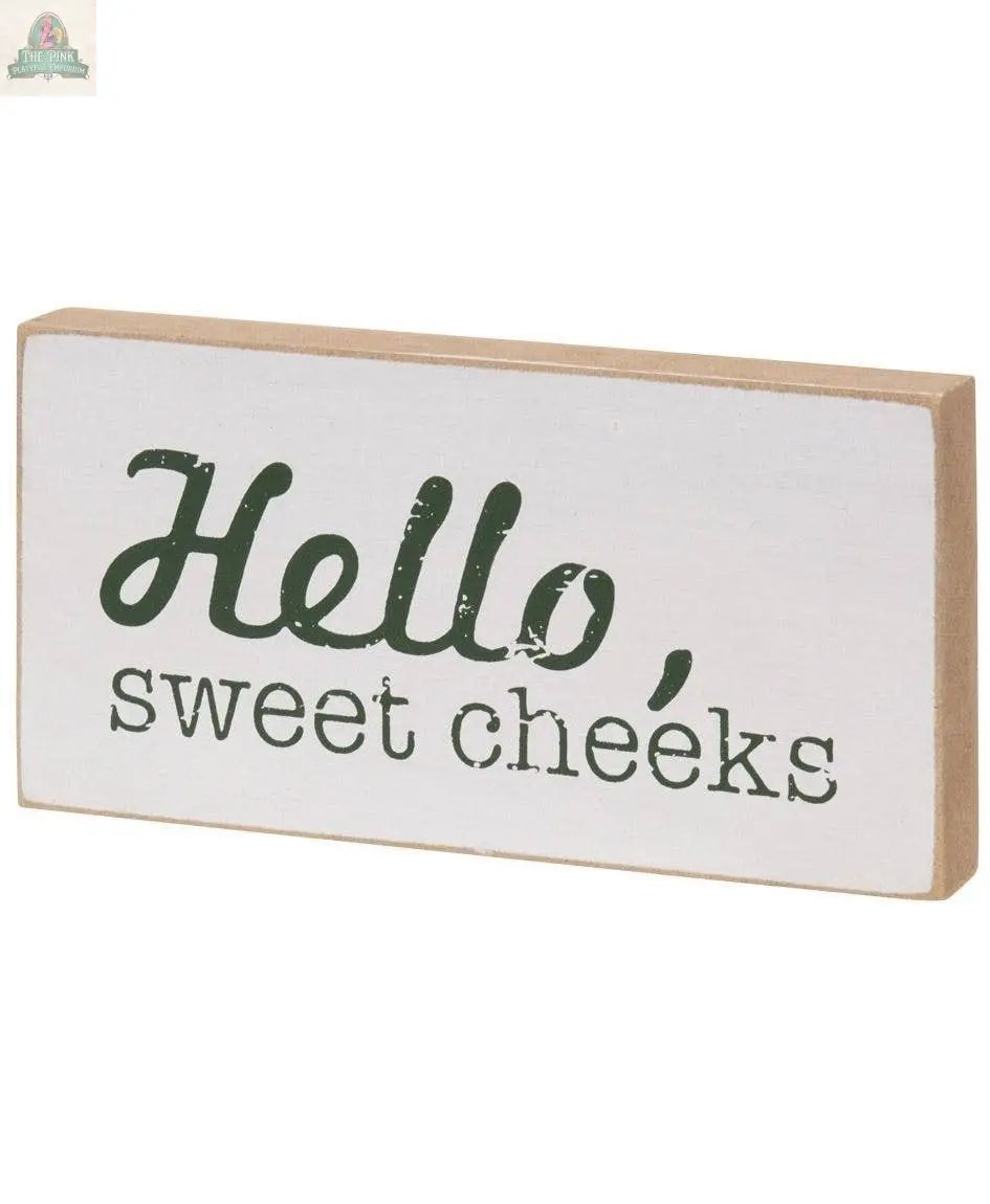 The Toilet Block Sign Assorted/2 is a rectangular rustic wood sign with a white front, brown edges, and “Hello, sweet cheeks” in playful green font—perfect for adding humor to your bathroom decor.