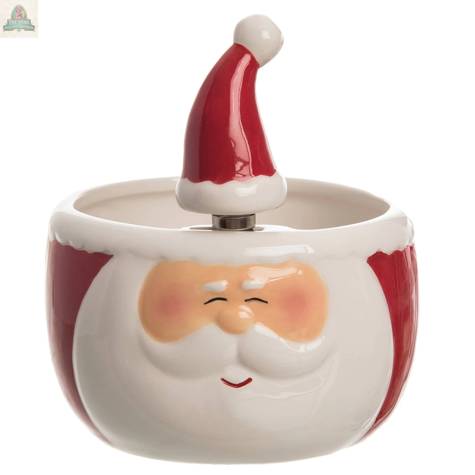 The Transpac Dol Santa Bowl w/Spreader S/2 is a festive ceramic bowl shaped like Santa's smiling face, complete with a red hat handle. Ideal for Christmas décor, it features rosy cheeks and closed eyes—perfect for the holiday season.