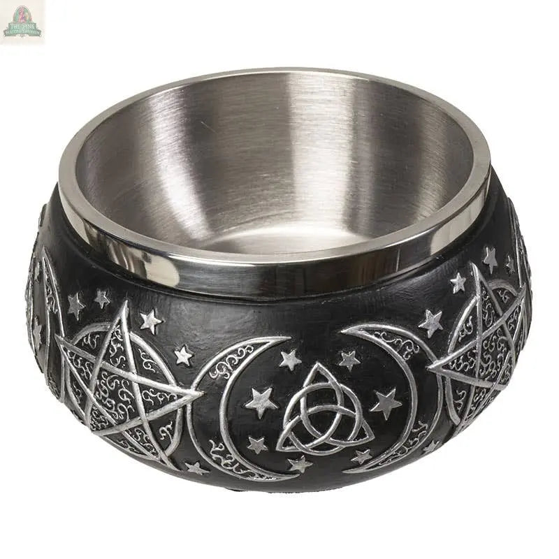 The Triple Moon Resin Smudge Ritual Offering Bowl features a black outer layer with embossed silver pentagrams, crescent moons, stars, and triquetra symbols. Its shiny stainless steel interior is perfect for use as a smudge or offering bowl.
