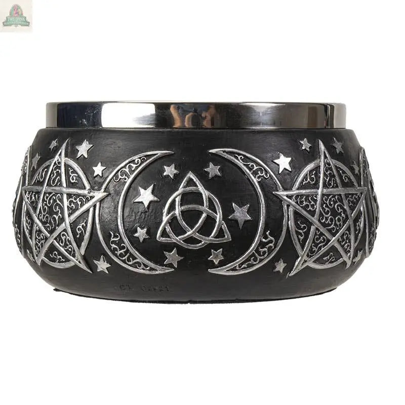 The Triple Moon Resin Smudge Ritual Offering Bowl features engraved silver pentagrams, crescent moons, stars, and a triquetra on black resin with a metallic rim—perfect as an offering bowl for your altar or sacred space.