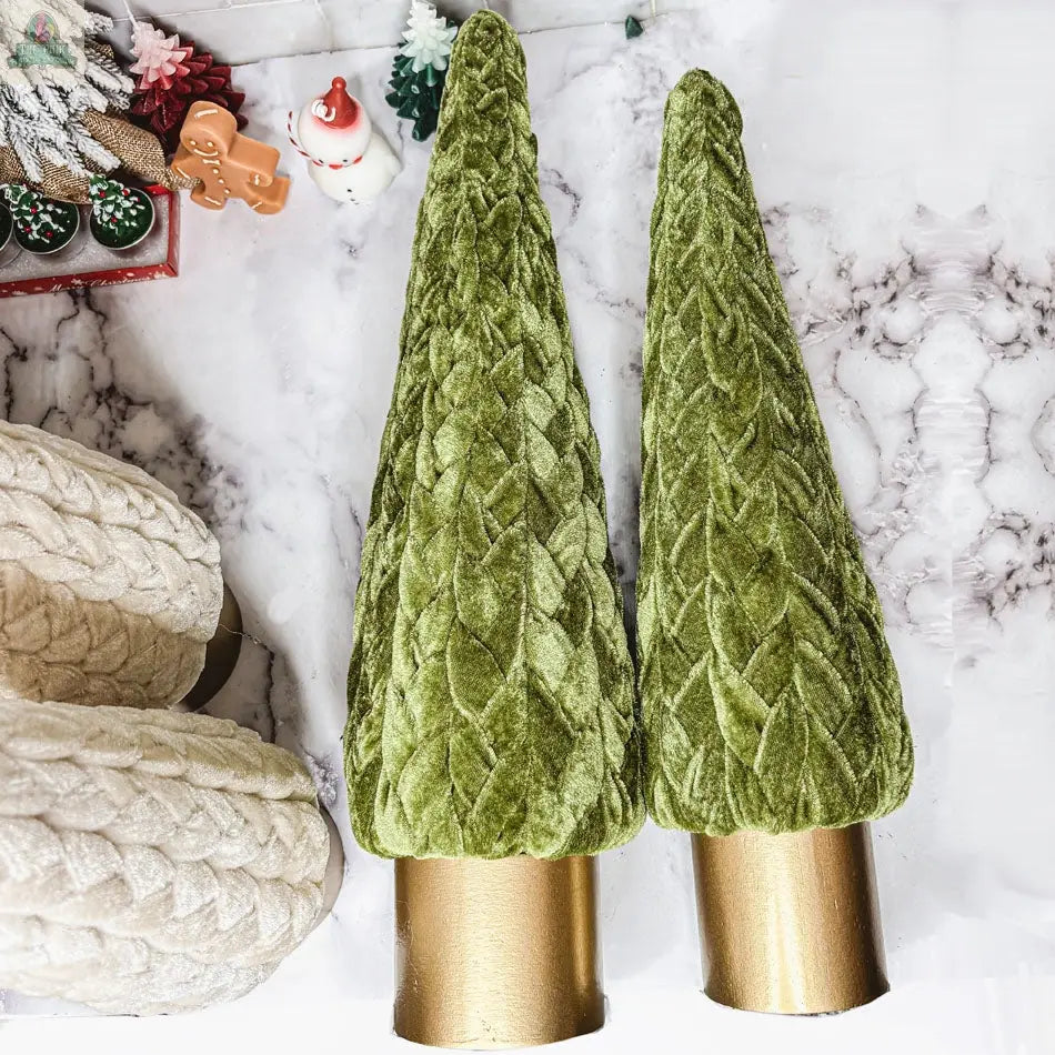 Two green Velvet Christmas Trees with gold bases sit on marble, complemented by a cream knit accent and small festive figurines like Santa and a reindeer, bringing charming farmhouse style to your holiday decor.