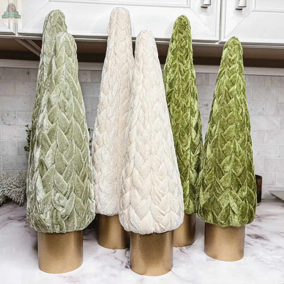 Six Velvet Christmas Trees, cone-shaped and quilted in green and cream, stand on gold bases atop a marble counter, bringing festive décor to a bright kitchen backdrop.