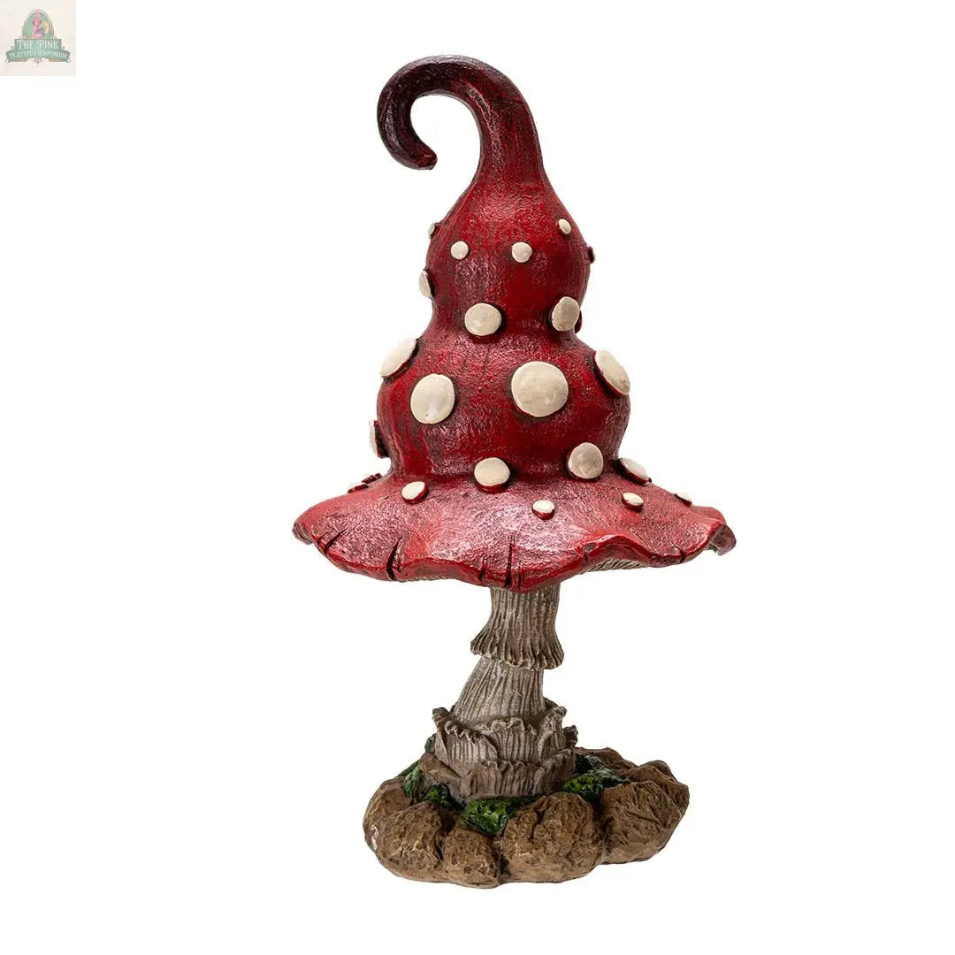 The Whimsical Toadstool Mushroom Home and Garden Decor features a red, white-spotted, twisted cap atop a textured brown stem and rocky base—ideal cottagecore decor and a charming addition to your mushroom statue collection.
