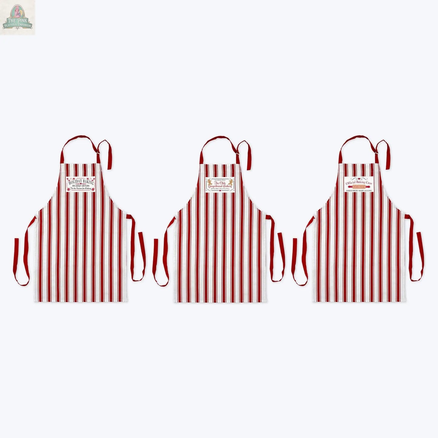 Three Young's Woven Holiday Baking Christmas Apron Assortment aprons, with red and white vertical stripes, red straps, and a chest label, are shown side by side on a plain white background.