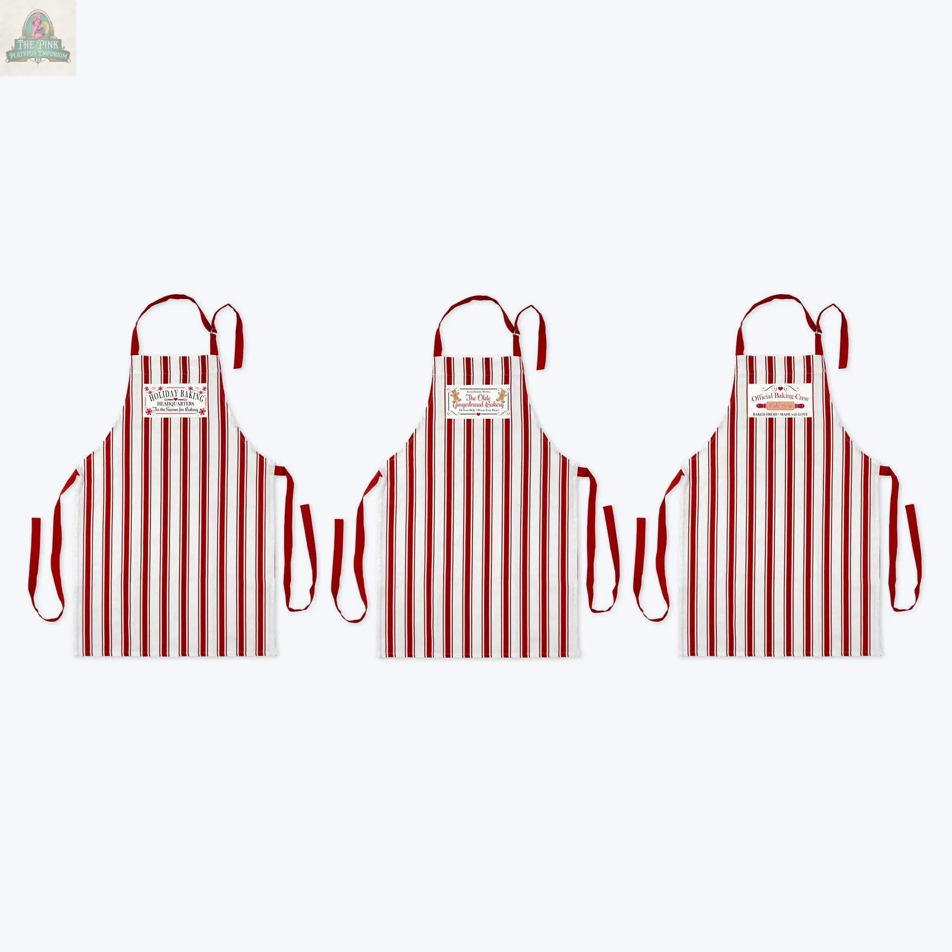 Three Young's Woven Holiday Baking Christmas Apron Assortment aprons, with red and white vertical stripes, red straps, and a chest label, are shown side by side on a plain white background.