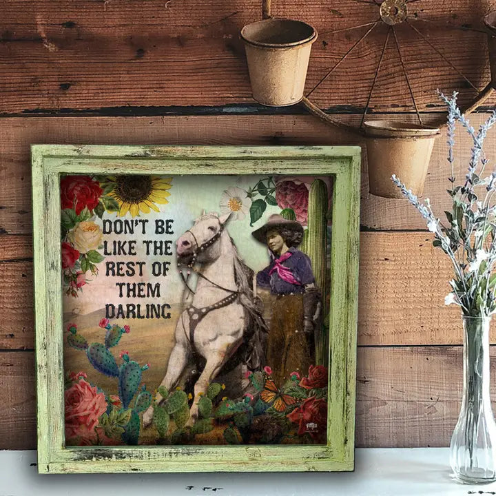 Decorative wall art with a woman on horseback and floral text against a wooden background.