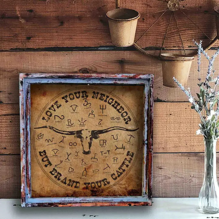Decorative sign with longhorn bull design and text on a wooden wall.