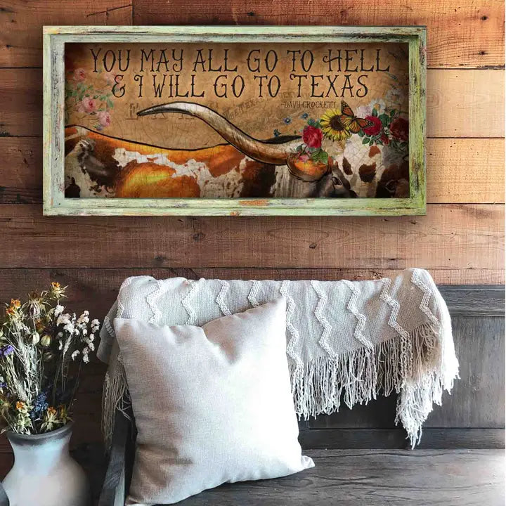 Texas wall art with text and cow skull on a wooden wall above a couch.