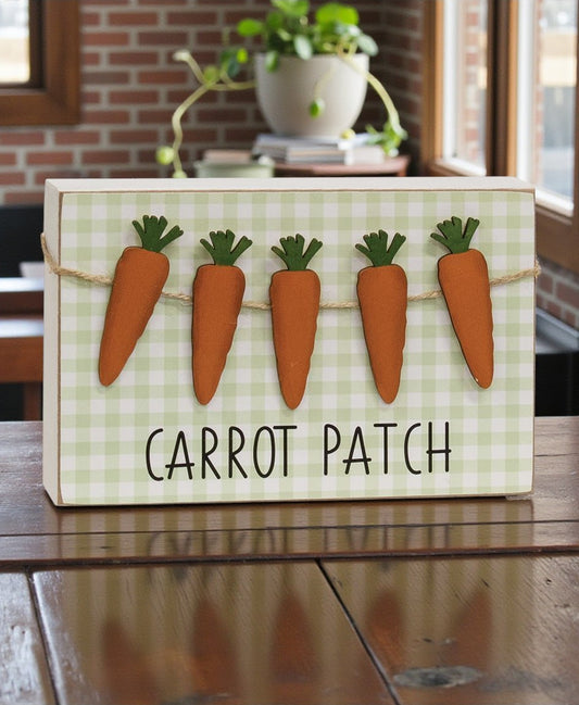 Decorative sign with cartoon carrots and 'Carrot Patch' text on a checkered background.