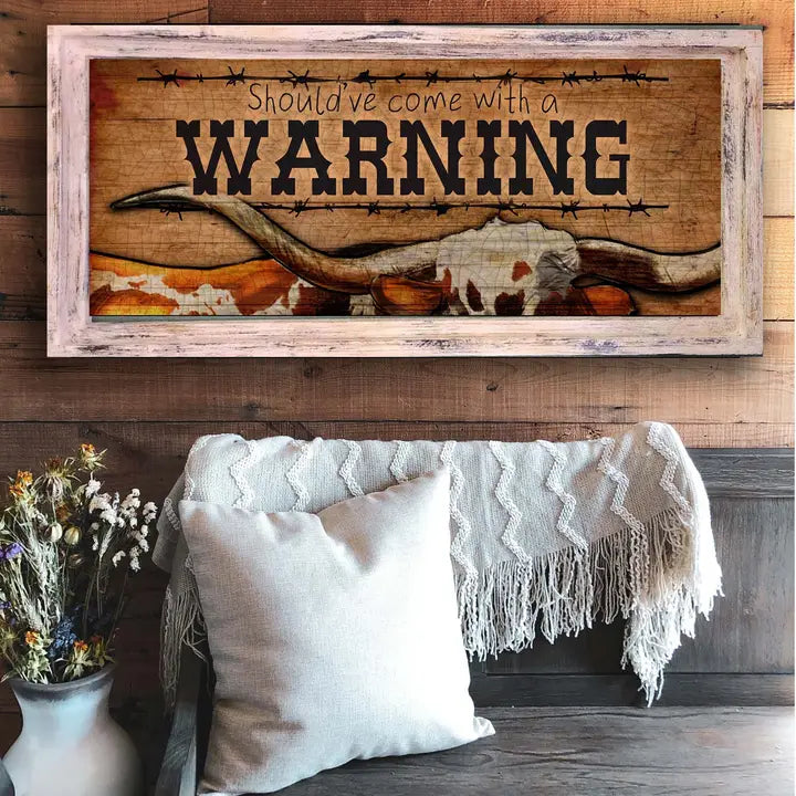 Western wall art with 'Should've come with a WARNING' text above a cozy living room setting.