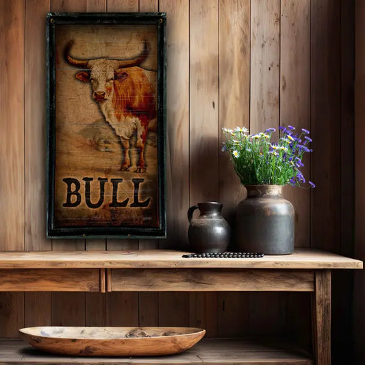 Wooden shelf with rustic western wall art with a bull-themed framed picture, two vases, and a bowl against a wooden wall.