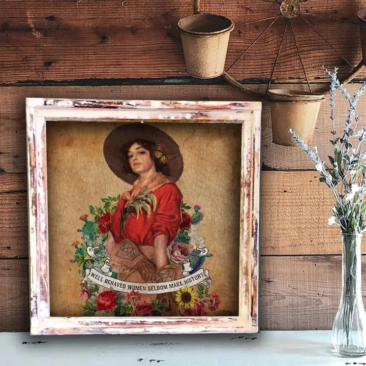 Framed artwork of a woman with flowers and text on a wooden wall.