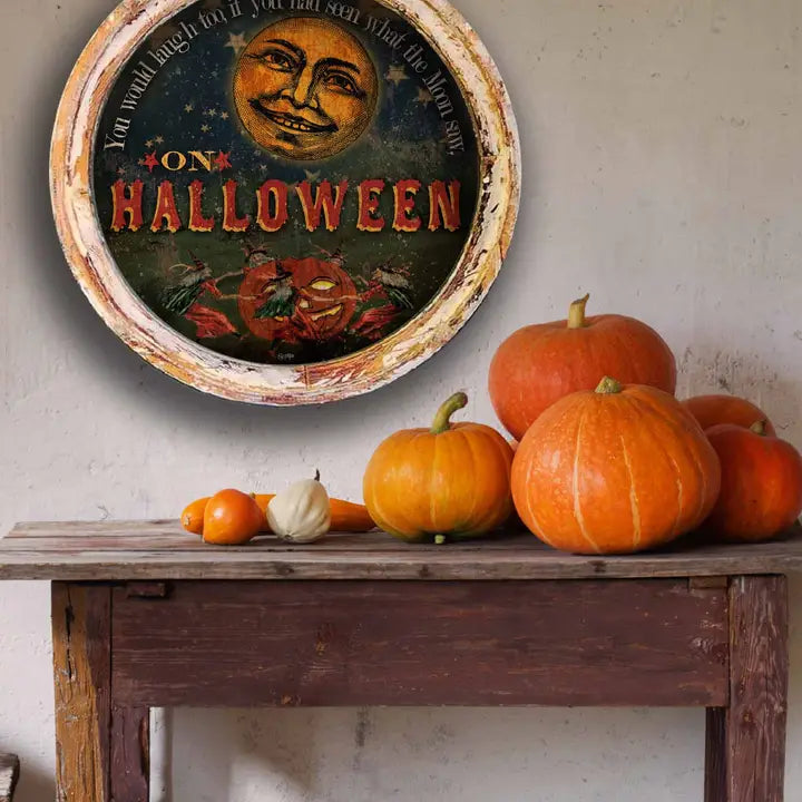 Vintage-style rustic wall art with pumpkins on a wooden table against a light wall.