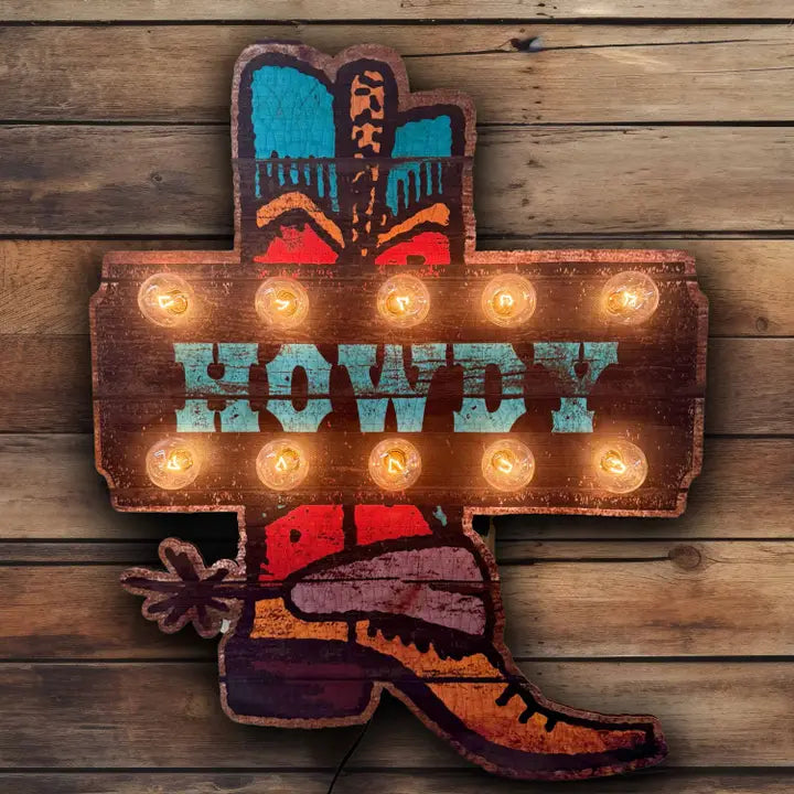 Decorative sign with 'Howdy' text and cowboy boot design on a wooden background