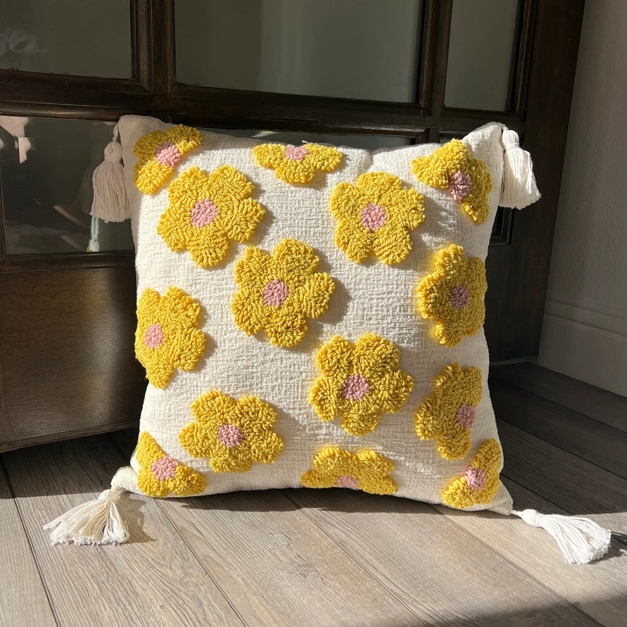 Decorative pillow with yellow flower patterns on a wooden floor