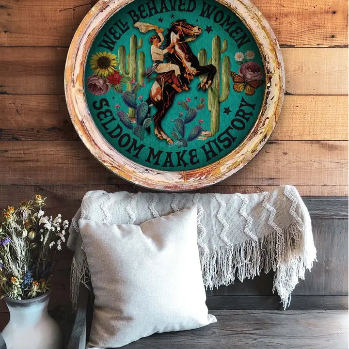 wester wall art with a cowgirl and horse and cactus design on a wooden wall.