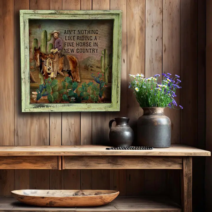 western wall art featuring a cowboy on a wooden wall with decorative vases and a bowl below.