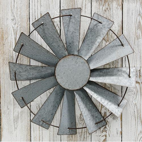 Decorative metal wall art with a sunburst design on a wooden background
